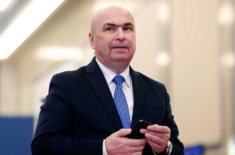 Премьер-министр Румынии Илие Боложан помогает убирать мусор после партийного съезда